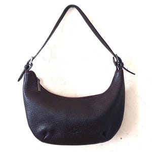 May include: A dark brown leather shoulder bag with a curved shape and a single strap.