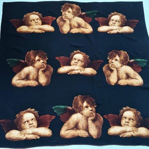 May include: A dark navy blue fabric featuring a repeating pattern of cherubs with brown hair and reddish-brown wings. The cherubs are depicted in various poses, some resting their chins on their hands, all set against the solid dark background.