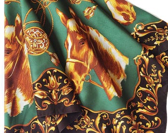 Può includere: Una sciarpa di seta verde con un motivo a testa di cavallo con accenti marroni e oro. La sciarpa ha un bordo marrone scuro con motivi floreali dorati e dettagli di corda. Le teste di cavallo sono rivolte in direzioni diverse.