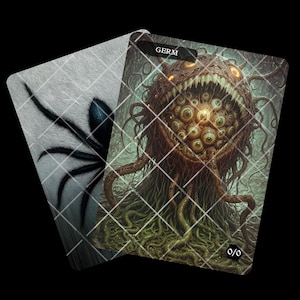 May include: Two fantasy art cards. One card features a black spider on a gray background. The other card depicts a grotesque creature with many eyes, sharp teeth, and the word "GERM" at the top. The creature is brown and green.