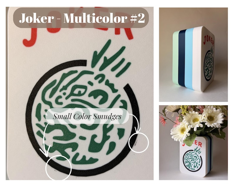 May include: A white rectangular vase with rounded corners featuring the text Joker - Multicolor #2 and a circular green abstract graphic. The side panels display vertical stripes in light green, dark blue, and light blue. Small color smudges are visible.