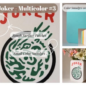 May include: A white rectangular block with the red text JOKER and a circular green graphic. The block features rough surface patches, small color smudges, and a turquoise back. It is shown as a container holding a bouquet of artificial flowers.