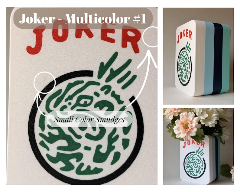 May include: A rectangular white vase with rounded corners featuring the red text Joker and a circular green graphic design. The side panels are layered in white, light blue, dark blue, and teal. Small color smudges are visible on the surface.