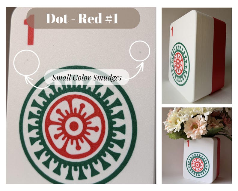 May include: A white rectangular container with a red side, featuring a red number 1 and a circular green and red floral-style graphic. The surface shows small color smudges. The object is shown from multiple angles, including one with flowers.