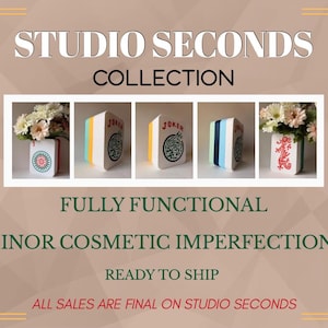 May include: A collection of five rectangular vases designed to resemble mahjong tiles, featuring various colorful patterns and symbols including a red dragon and the word JOKER. The text STUDIO SECONDS COLLECTION, FULLY FUNCTIONAL, MINOR COSMETIC IMPERFECTIONS, READY TO SHIP, and ALL SALES ARE FINAL ON STUDIO SECONDS is displayed.