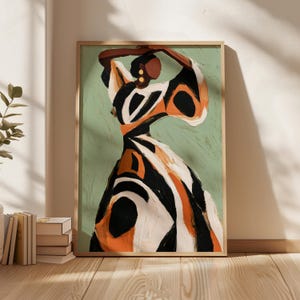 May include: Abstract art print featuring a figure in a flowing dress with bold black, white, and orange patterns. The artwork is set against a muted green background and framed in a natural wood frame, creating a modern aesthetic.