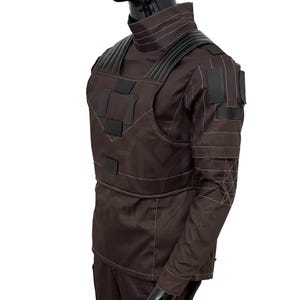 Puede incluir: Un chaleco t&aacute;ctico y uniforme marr&oacute;n con detalles en negro. El chaleco presenta m&uacute;ltiples parches y correas rectangulares, con costuras blancas. El uniforme tiene cuello alto y mangas largas. El conjunto se exhibe en un maniqu&iacute;.