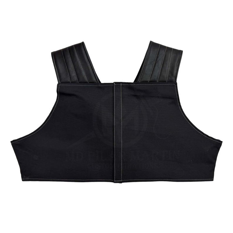 May include: A black sleeveless top with a black leather trim around the neckline. The top has a straight neckline and a cropped length.