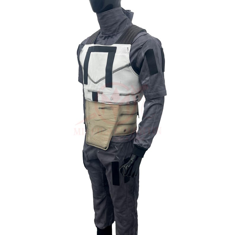 May include: A gray costume with a white chest plate and a tan midsection. The costume includes a long-sleeved shirt, pants, and gloves. The chest plate has black accents. The costume is displayed on a mannequin.