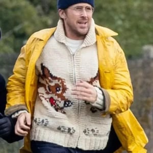 May include: A person wearing a navy blue beanie, glasses, and a yellow raincoat. They are also wearing a cream-colored zip-up sweater with a brown dog design. The sweater has Japanese characters at the bottom.