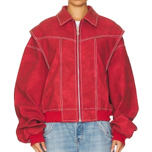 May include: A red jacket featuring a fold-down collar, a silver-toned front zipper closure, and white contrast stitching throughout. The garment includes a layered shoulder design, long sleeves with ribbed cuffs, and a ribbed hemline at the waist.