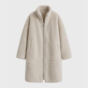 May include: A long, beige, faux-shearling coat featuring a high collar, long sleeves, and a full-length front zipper closure. The garment has a textured, fleece-like exterior with two vertical side pockets and a straight hemline.