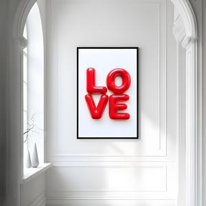 May include: A framed print with the word "LOVE" in large, red, glossy letters against a white background.