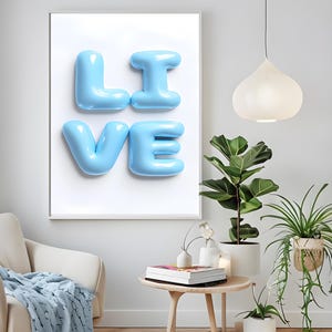 May include: A framed print with the word "LIVE" spelled out in large, light blue, balloon-like letters against a white background.