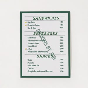 May include: A green and white menu with the title "Sandwiches", "Beverages", and "Snacks". The menu lists various food and drink items with their prices. The menu also includes the text "Designs by Janb".