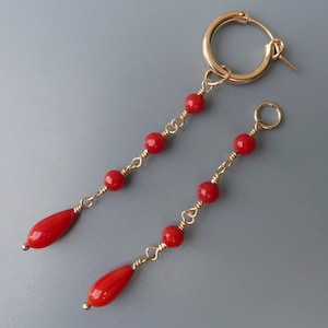 Puede incluir: Un par de pendientes de gota de coral rojo con aros de oro y una cadena de pequeñas cuentas de coral rojo.