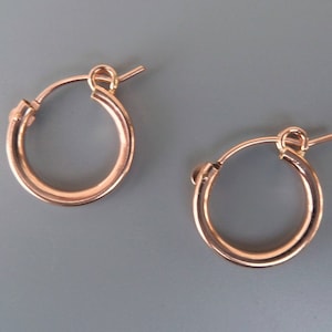 Puede incluir: Un par de pendientes de aro de oro rosa. Los pendientes son simples y elegantes, y serían un gran regalo para cualquier ocasión.