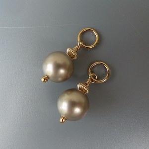 Puede incluir: Dos abalorios dorados con una perla y un anillo de oro. Los abalorios son perfectos para añadir un toque de elegancia a las joyas o las manualidades.