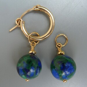 May include: Gold-tone hoop earrings with dangling round beads. The beads are a mix of blue and green, with a gold-tone cap and a small gold bead at the bottom. The earrings are displayed against a gray background.
