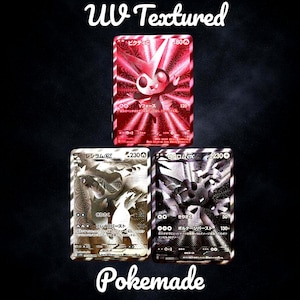 May include: Three UV textured trading cards. The top card is red with a white character. The bottom left card is silver with a white character. The bottom right card is black with a white character. Text on the cards includes "UV Textured" and "Pokemade".