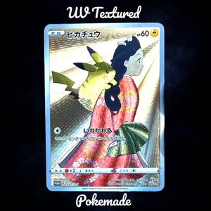 May include: A UV textured trading card featuring Pikachu and a woman in a kimono. The card has a holographic effect with Japanese text and the word "Pokemade" at the bottom. The woman is wearing a red kimono.