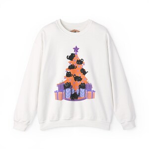 Può includere: Felpa bianca girocollo con un design ad albero di Natale fatto di gatti neri. L'albero è decorato con una stella viola e poggia su regali avvolti. La felpa ha maniche lunghe e scollo tondo.