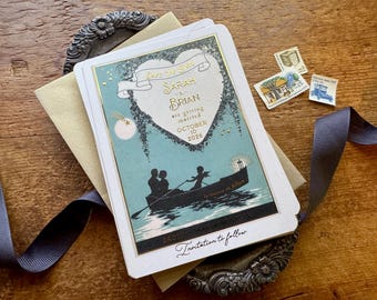 May include: Vintage-style wedding invitation with a teal and gold design. The invitation features the text "Save the Date" and the names "Sarah & Brian" with the date "October 10, 2026." A boat with two figures is depicted on the invitation. Includes a ribbon and stamps.