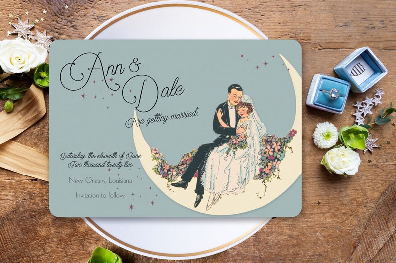 Puede incluir: Una tarjeta de anuncio de boda azul claro con una pareja sentada en una luna creciente. La tarjeta presenta una ilustraci&oacute;n vintage de la pareja con atuendos formales. El texto en la tarjeta dice "Ann & Dale Are getting married! Saturday, the eleventh of June Two thousand twenty two New Orleans, Louisiana Invitation to follow."