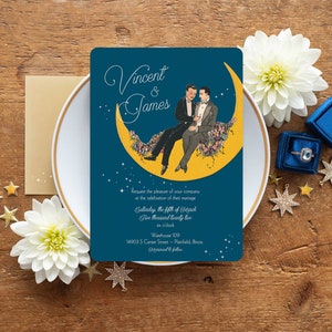 Puede incluir: Una invitaci&oacute;n de boda azul con una luna creciente amarilla y dos hombres con traje sentados en ella. La invitaci&oacute;n dice "Vincent & James" e incluye la fecha, la hora y el lugar de la boda.