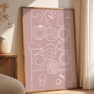 Könnte beinhalten: Ein rechteckiger Wandkunstdruck in einem Holzrahmen mit einem altrosa Hintergrund und einer weißen Strichzeichnung einer gedeckten Tafel. Die Illustration zeigt Teller, Obstschalen, Besteck und Servietten auf einer Tischoberfläche.