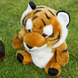 Puede incluir: Un peluche de tigre con pelaje marr&oacute;n, negro y blanco est&aacute; sobre hierba verde. El tigre tiene rayas negras, vientre blanco y patas negras. El juguete est&aacute; dise&ntilde;ado para parecerse a un cachorro de tigre amigable.