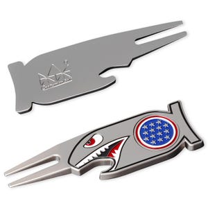 May include: Two silver golf divot tools. One tool has the embossed text "Craftsman Golf". The other tool has a shark graphic with a red and white mouth, a blue and red circle with stars, and a silver body.