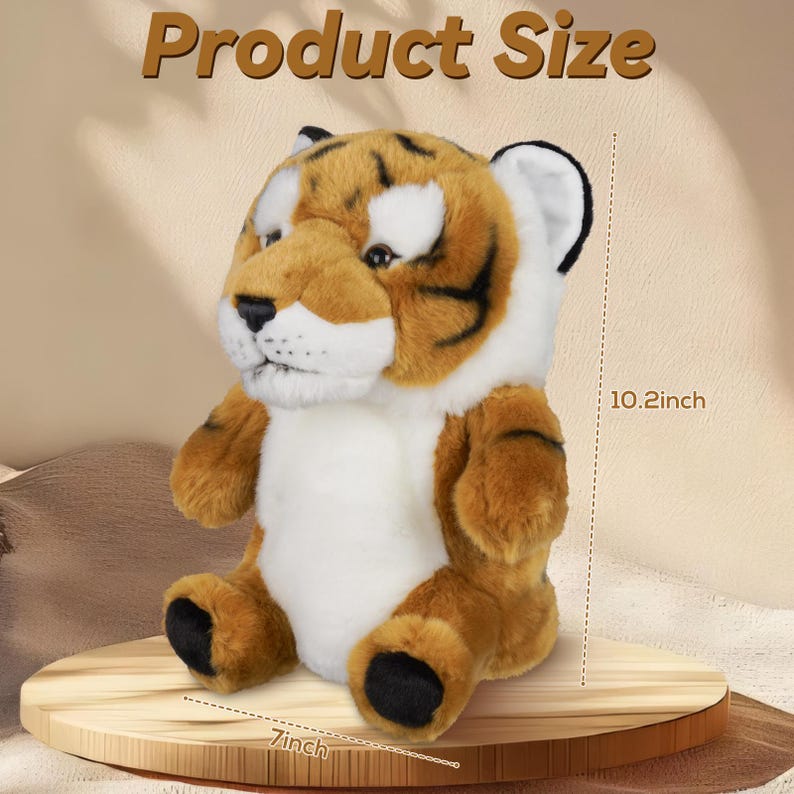 Puede incluir: Un juguete de peluche de tigre con pelaje marr&oacute;n y blanco, rayas negras y patas negras. El juguete mide 26 cm de alto y 18 cm de ancho. El texto "Product Size" se muestra en la parte superior de la imagen.