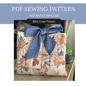 Op de afbeelding: Een gewatteerde Bijbelhoes met een bloemenpatroon in perzik, blauw en bruin. Het heeft een grote blauwe strik met witte stippen. De tekst bovenaan luidt "PDF Sewing Pattern" en "Instant Download".
