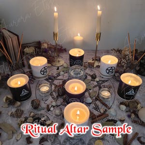 May include: A ritual altar arrangement featuring lit candles in black and white containers, decorated with pentagram and Celtic knot symbols. There are tall candles in gold holders and smaller votives. The text "Ritual Altar Sample" is visible.
