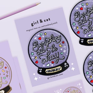 May include: Purple iron-on patch with a white background and a purple, embroidered, glass ball with the text "Everything will be okay (probably)" inside. The patch is surrounded by stars and hearts.