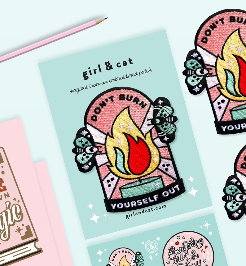 Pu&ograve; includere: Tre toppe ricamate da stirare con uno schema di colori rosa e giallo. Le toppe presentano una fiamma con il testo "Don't Burn Yourself Out" e una falena con un occhio. Sono anche visibili il testo "girl & cat" e il sito web "girlandcat.com".