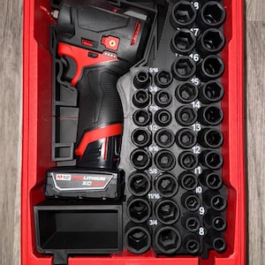 May include: A red toolbox with a clear lid, containing a black and red power drill and a set of black sockets. The drill has a black handle and a red base. The sockets are arranged in a vertical row, with sizes labeled.