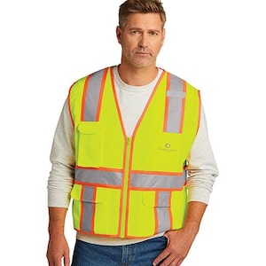 Peut inclure: Un gilet de sécurité jaune avec des bandes réfléchissantes et des bordures orange. Le gilet a deux poches sur le devant et une fermeture à glissière. Le gilet porte l'inscription "Project Guard" imprimée sur le devant.