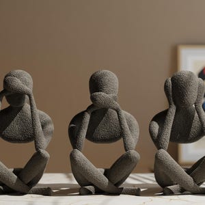 Può includere: Tre sculture in pietra grigia di figure sedute con le mani che si coprono gli occhi, le orecchie e la bocca. Le sculture sono disposte in fila da sinistra a destra.