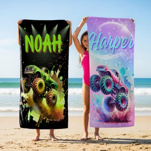 Könnte beinhalten: Zwei Strandtücher mit Monster-Truck-Designs. Eines ist schwarz mit dem Namen "Noah" in Grün und einem grünen Monster-Truck. Das andere ist lila mit dem Namen "Harper" in Blau und einem pinkfarbenen Monster-Truck. Beide werden an einem Strand gehalten.