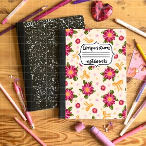 May include: Composition notebook with a floral design, next to a black and white composition notebook. The floral notebook has pink flowers and yellow bows. Pencils and pens in shades of pink and purple surround the notebooks.