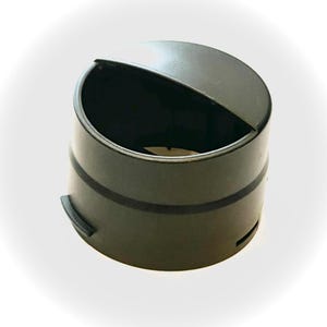 May include: A black plastic bottle cap with a hinged lid. The lid is open and the cap has a groove around the top.