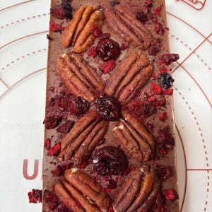 Milk chocolate bar with pecan and cherry 100g .