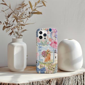 K&ouml;nnte beinhalten: Dekorative Handyh&uuml;lle mit einem Collage-Design. Sie zeigt einen Golden Retriever, der Blumen h&auml;lt, einen Leuchtturm und florale Elemente. Die H&uuml;lle hat ein blaues und rosa Farbschema mit einer Schleife und der Zahl 8.