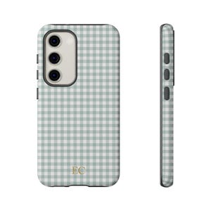 May include: A phone case with a light green and white gingham pattern. The case has a camera cutout and side buttons. The initials "EC" are in gold at the bottom. The case is shown from the front and side.
