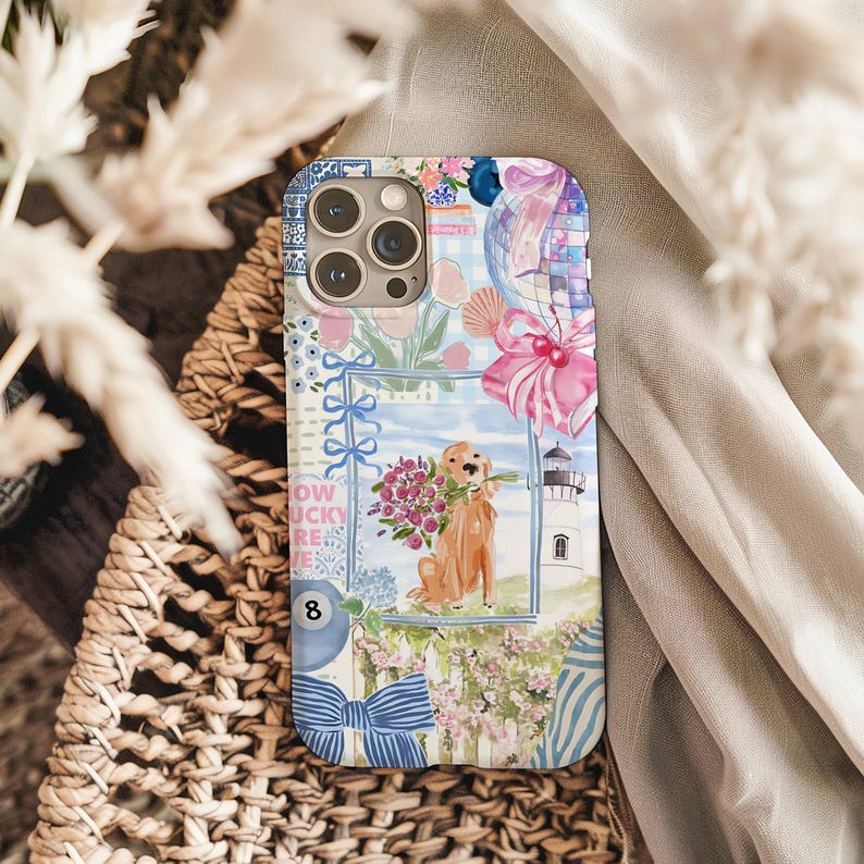 K&ouml;nnte beinhalten: Dekorative Handyh&uuml;lle mit einer Aquarellillustration eines Golden Retrievers, der Blumen h&auml;lt, vor einer K&uuml;stenlandschaft mit Leuchtturm und floralen Akzenten. Das Design hat ein Collage-Design mit blauen und rosa Elementen.