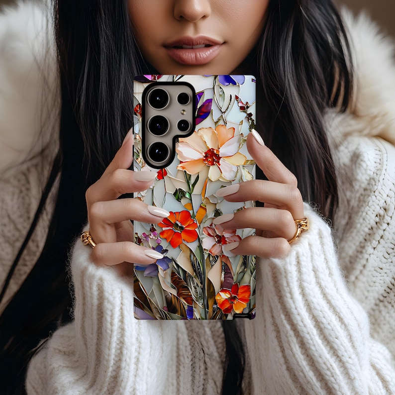 May include: A phone case with a floral design featuring colorful flowers and leaves. The case has a cutout for the camera lens.
