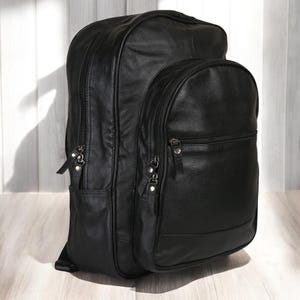 May include: A black leather backpack with multiple zippered compartments and a large main compartment.
