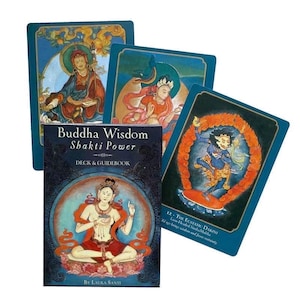 May include: A deck and guidebook titled "Buddha Wisdom Shakti Power" with illustrations of spiritual figures. The deck includes several cards with colourful artwork and the text "12. The Ecstatic Dakini Lion-Headed Sinha Mukha".